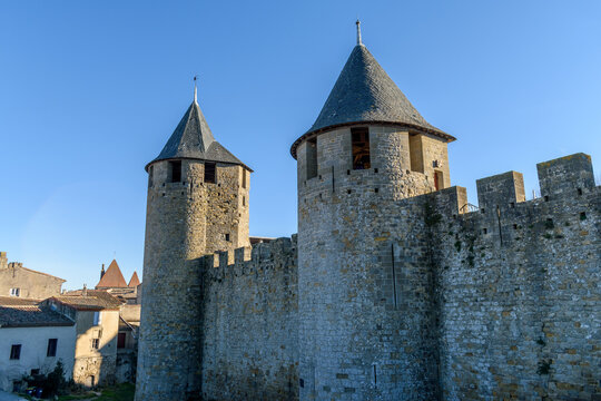 The Château Comtal, Count’s Castle, is a medieval castle in the Cité of Carcassonne, tall towers and wall, and a bridge to a fortified gate.
