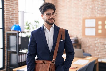 Fototapeta premium Young hispanic man business worker smiling confident standing at office