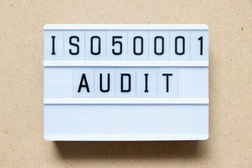 Lightbox with word ISO 50001 audit on wood background