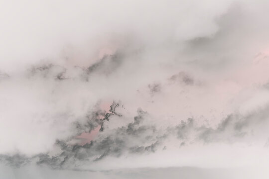 Abstract of clouds and sky at dusk, black grey and pink colours.