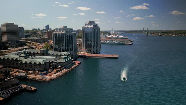 Aerial View of a Tourist Ship with Tourists Sailing Along the Business Center of Halifax Standing on the Waterfront by the Ocean Canada. Drone Shot on a City with Skyscrapers Ship Sailing Ocean.