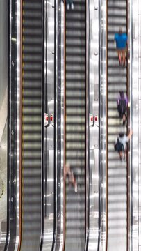 Vertical time-lapse of Asian people transport on escalator at subway underground station in Hong Kong. Public transportation, Asia city life, or commuter urban lifestyle concept. Top high angle view