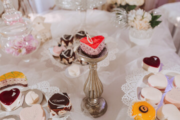 Festive dessert table with sweets. Wedding candy bar, various cakes, chocolates on stands.