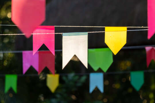 Detalhe de bandeirinhas coloridas de festa junina típica do Brasil com fundo desfocado