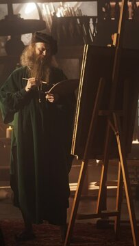 Vertical Screen: Old Male Renaissance Artist Painting on Canvas in his Antique Workshop. Talented Historical Figure Working on his Masterpiece and Feeling Inspired While Transfering Ideas on Canvas
