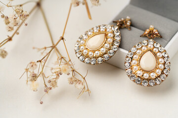 Golden earrings and jewelry box on table close up