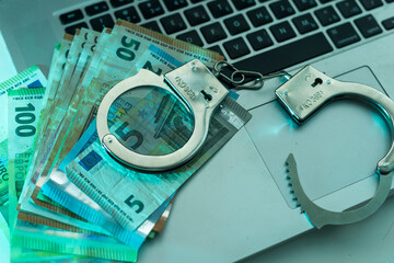 handcuffs lie on a pack of one hundred euros. High quality photo