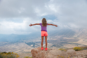 Joyful teen girl in the mountains