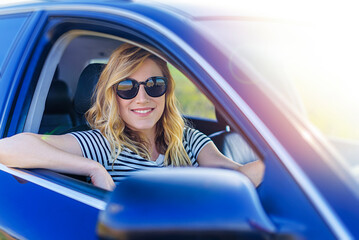 Beautiful blonde woman driving a car. Young woman in a car.
