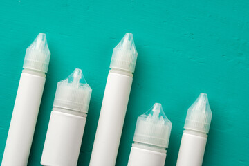 Electronic cigarettes liquid bottles on blue background