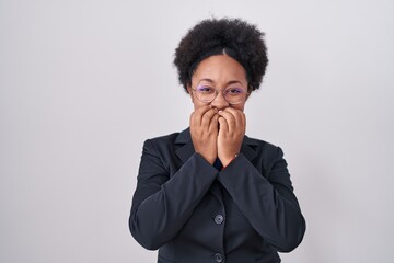 Beautiful african woman with curly hair wearing business jacket and glasses laughing and...