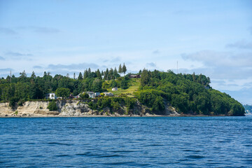 Ocean view from a boat at Puget Sound, state of Washington, USA. Scenic view of water, mountains, beach.