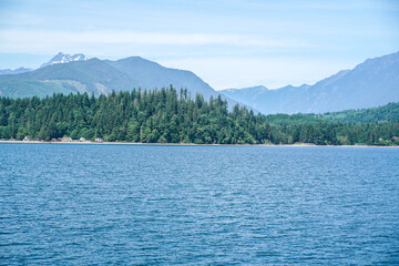 Ocean view from a boat at Puget Sound, state of Washington, USA. Scenic view of water, mountains, beach.