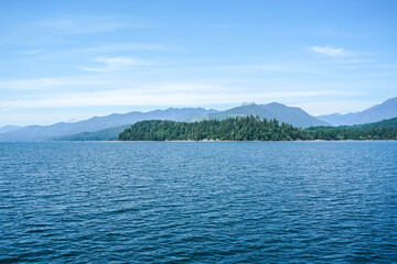 Ocean view from a boat at Puget Sound, state of Washington, USA. Scenic view of water, mountains, beach.