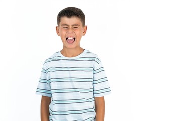 Fototapeta premium Little hispanic boy wearing striped T-shirt sticking tongue out happy with funny expression. Emotion concept.