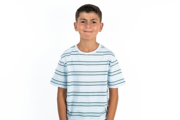 Displeased upset Little hispanic boy wearing  striped shirt  frowns face as going to cry, being discontent and unhappy as can't achieve goals,  Disappointed model has troubles