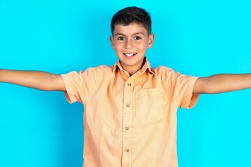 Photo of Little hispanic boy wearing orange shirt do selfie