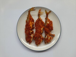 food balado fried mackerel (ikan kembung) on a plate top view on white background. healthy food...