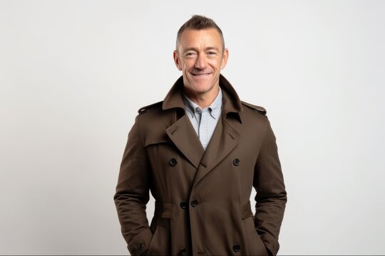 Portrait of a mature man in a trench coat on a white background