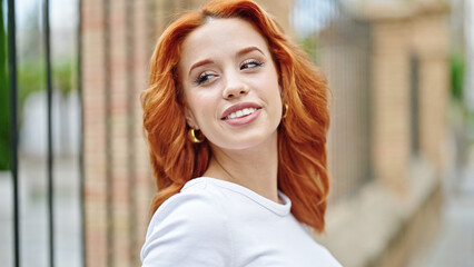 Obraz premium Young redhead woman smiling confident looking to the side at street
