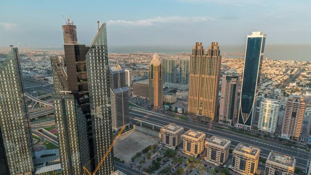 High-rise buildings on Sheikh Zayed Road in Dubai aerial morning timelapse, UAE. Skyscrapers in international financial district from above during sunrise. City walk houses and villas on background