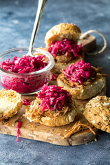 Toasted pulled pork buns topped with pickled red cabbage and beet sauerkraut.