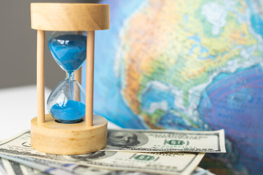 World globe with laptop and hourglass. Online business and globalisation theme