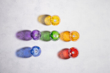Colorful goblets and their falling shadows on a white background