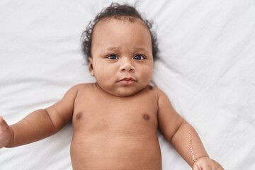 African american baby relaxing on bed at bedroom