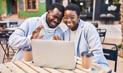Man and woman couple having video call sitting on table at coffee shop terrace