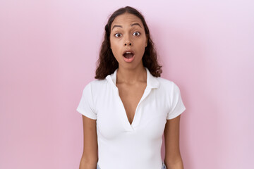 Young hispanic woman wearing casual white t shirt afraid and shocked with surprise and amazed expression, fear and excited face.
