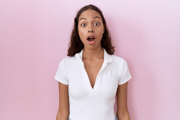 Fototapeta premium Young hispanic woman wearing casual white t shirt afraid and shocked with surprise and amazed expression, fear and excited face.