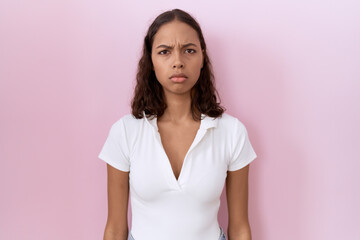 Obraz premium Young hispanic woman wearing casual white t shirt skeptic and nervous, frowning upset because of problem. negative person.