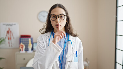 Young beautiful hispanic woman doctor asking for silent at clinic