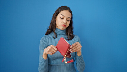 Young beautiful hispanic woman showing empty wallet over isolated blue background