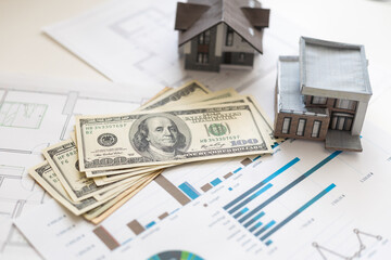 paper house model on background of US dollars banknotes. Housing market, purchase or rental of real estate