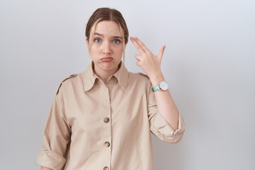 Young caucasian woman wearing casual shirt shooting and killing oneself pointing hand and fingers to head like gun, suicide gesture.