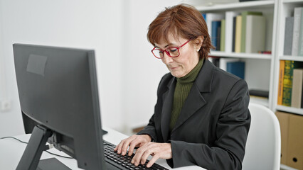 Mature hispanic woman university teacher using computer at library university