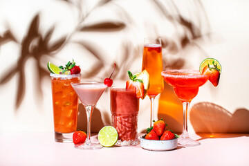 Strawberry cocktails set. Mocktails, smoothies and shakes with fruits and berries in glasses. Refreshing cold drinks and beverages. Beige pink background, hard light, shadow pattern