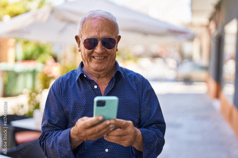 Canvas Prints Senior grey-haired man smiling confident using smartphone at street