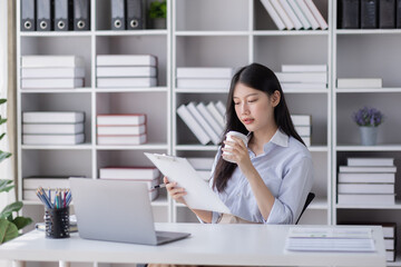 Business Asian woman work documents on laptop computer at office with calculator accounting on desk, do planning analyzing the financial report, business plan investment, finance analysis concept.