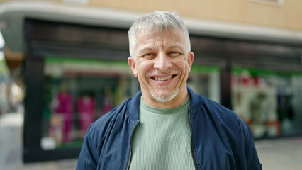 Middle age grey-haired man smiling confident standing at street