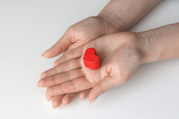 Female hands giving red heart on white background