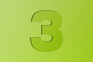 White paper type paper alphabet number 3 isolated on green background.