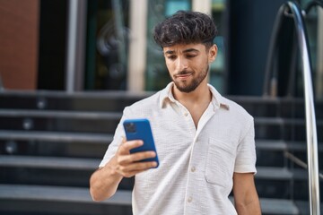 Young arab man using smartphone at street