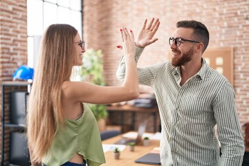 Man and woman business workers high five with hands raised up at office