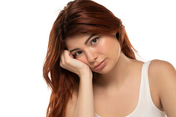 Portrait of sad redhead young woman on a white background