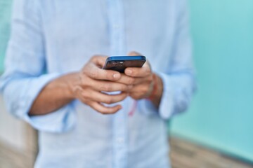 Young arab man using smartphone at street