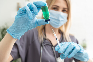 COVID-19 vaccine in researcher hands, female doctor's holds syringe and bottle with vaccine for...