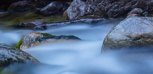 River water flows over rocks in rapids captured in slow motion in the tropical cloud forest.
Milky appearance. Slow motion water running through the forest among the jungle. Slow shutter speed.